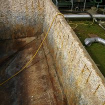 Znaczne uszkodzenia korozyjne belek wzmacniających oraz betonu w zbiorniku ścieków pod wpływem oddziaływania substancji chemicznych